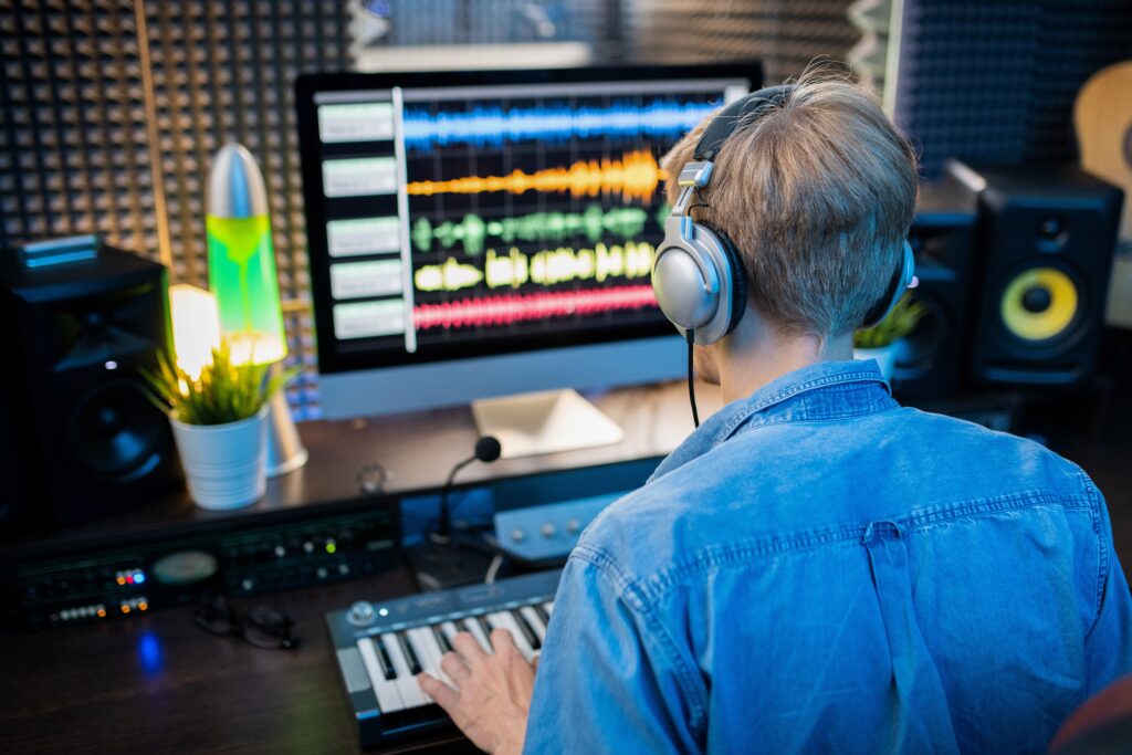 Man with headsets watching a screen with audio waves